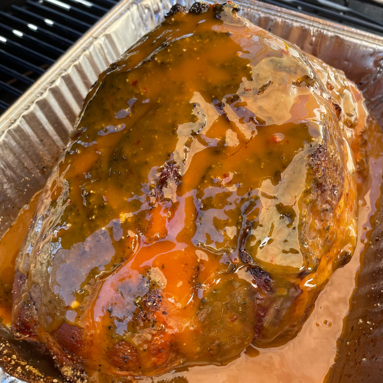Smoked ham on the grill with a carolina mustard glaze